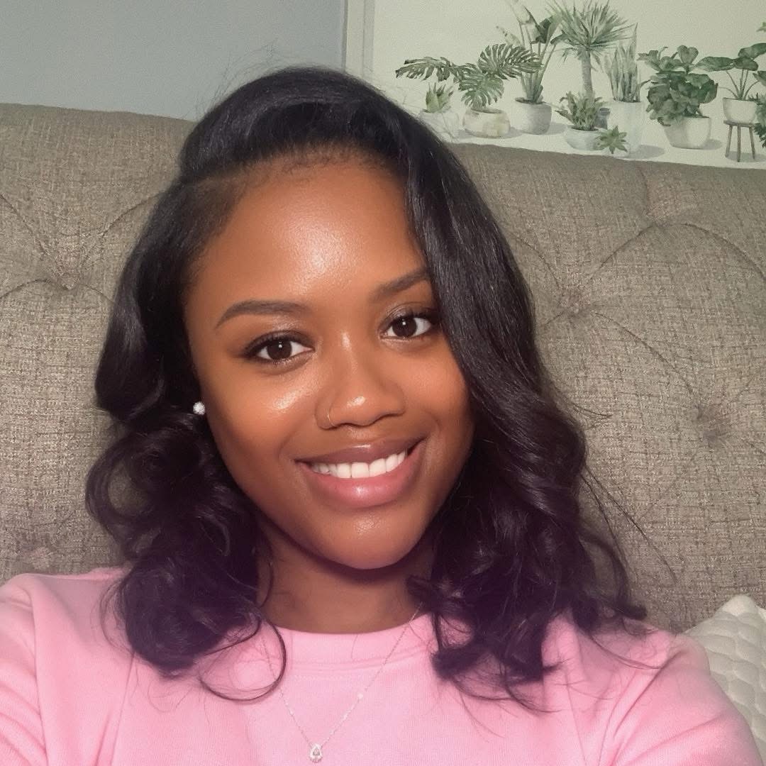 Kita Gaither, owner of LG's iPhone Repair, smiling in a pink sweater